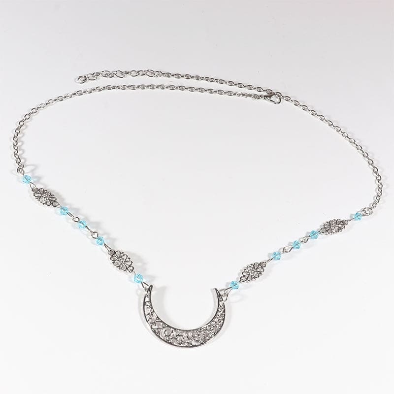 Silver-tone crescent chain headdress with small pale blue beads, arranged in an oval on a pale background with the clasp and chain visible.