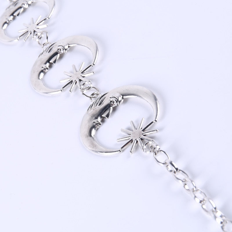 Close view of three crescent moon links with small star accents, showing their raised facial details and connecting rings.
