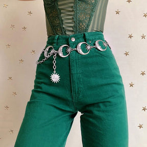 The moon-and-star belt photographed closer against green trousers, showing the linked crescents and long charm chain.