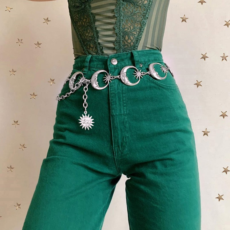The moon-and-star belt photographed closer against green trousers, showing the linked crescents and long charm chain.