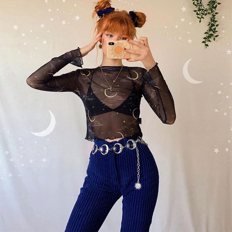 Full outfit view of the silver moon belt over blue flared trousers, styled with a black celestial-print top in a mirror portrait.