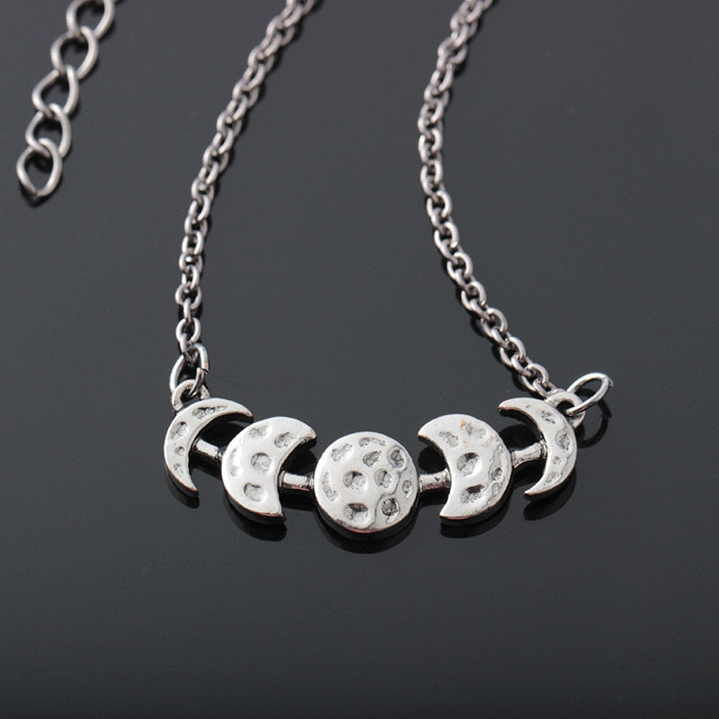 Silver-tone moon phase necklace with a close view of the textured moon shapes.