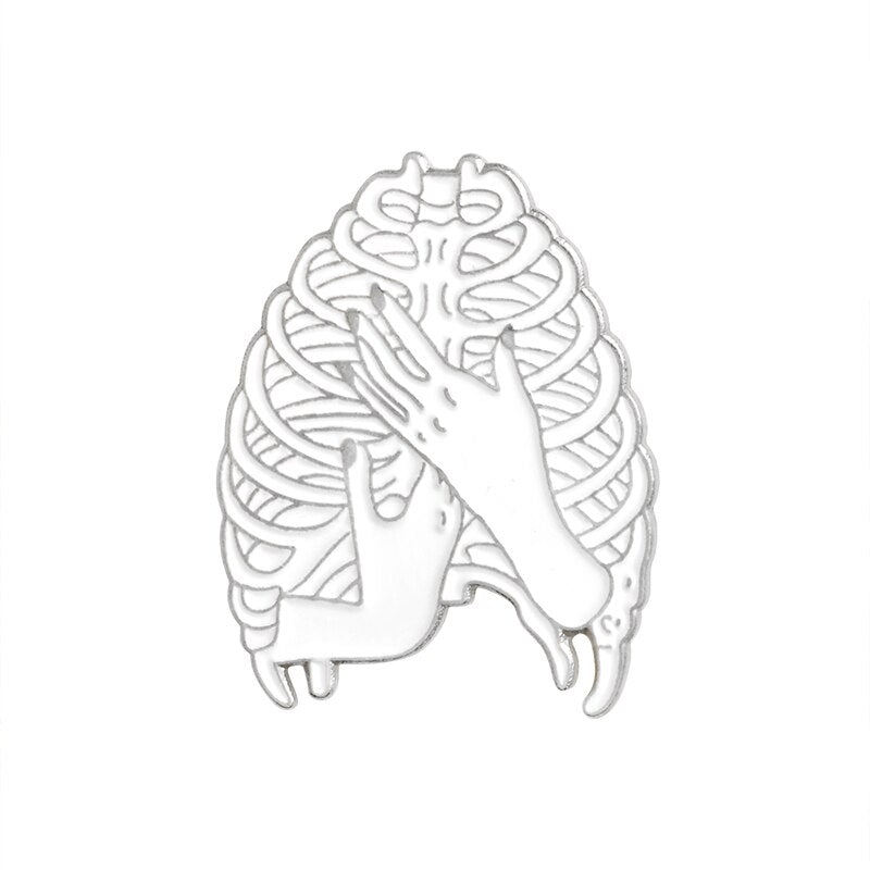 Silver-tone ribcage pin with an open skeletal outline and two hands crossed over the front.