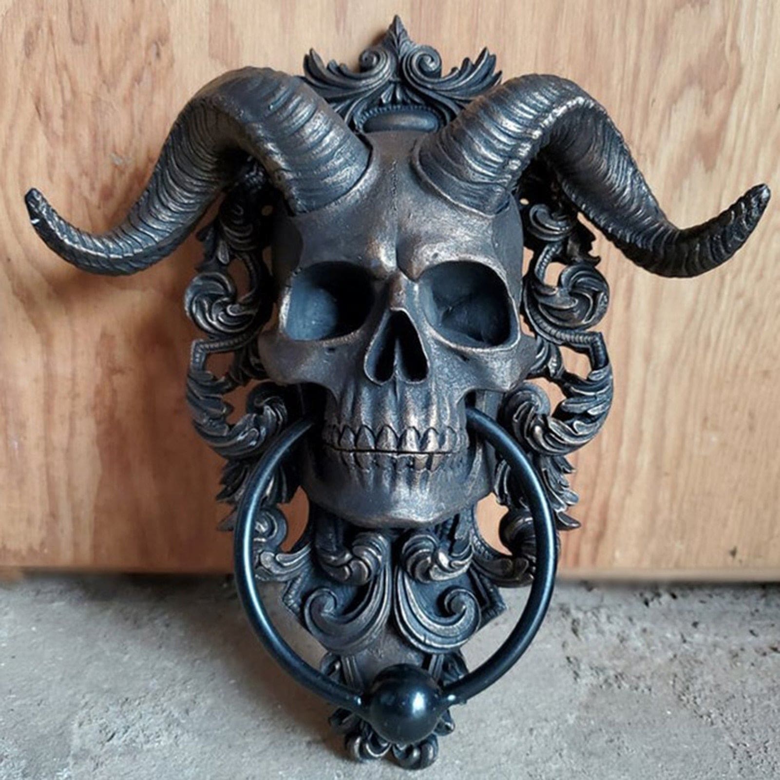 Horned skull door knocker scrollwork close-up