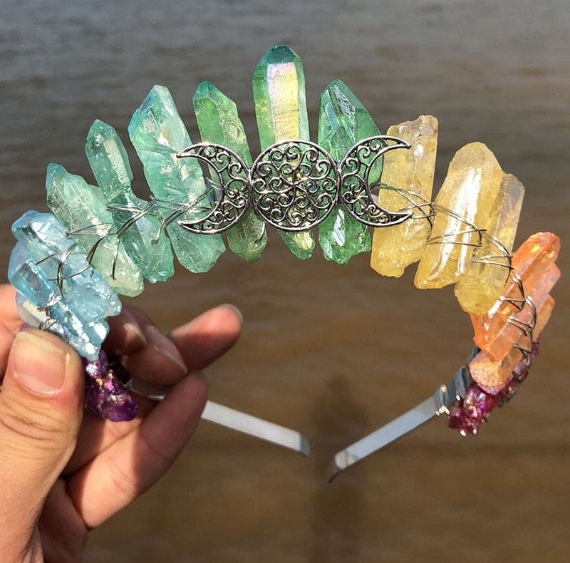 Front view of a soft rainbow crystal point crown with a silver-tone triple moon emblem and wire-wrapped band.