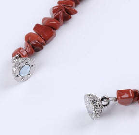 Red stone chip bracelet with its magnetic clasp separated into two halves, showing the fastening surfaces.