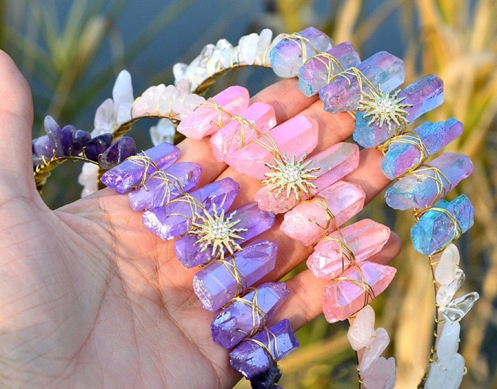 Outdoor view of purple, pink and iridescent sun tiaras, grouped to compare their crystal colours and golden centres.