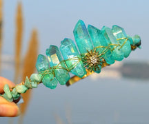 Teal crystal point tiara with a gold-tone sunburst, blue-green points and warm wrapped wire details.