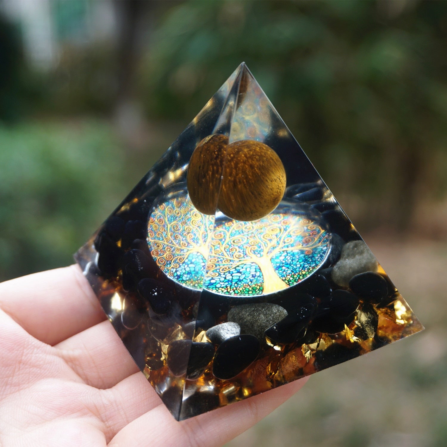 Additional view of Tiger eye and obsidian orgone pyramid with a golden-brown sphere and blue Tree of Life inlay. Another copy of the angled view shows the brown sphere above the reflective circular artwork.