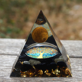 Additional view of Tiger eye and obsidian orgone pyramid with a golden-brown sphere and blue Tree of Life inlay. A repeated wood display view shows the golden sphere and black stone layer.