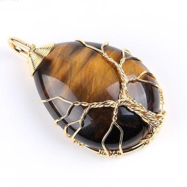 Brown striped tiger eye pendant wrapped with a gold-tone tree, showing warm bands behind the branches.