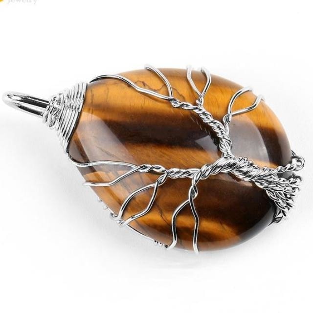 Tiger eye pendant with silver-tone Tree of Life wirework over a polished brown striped stone.