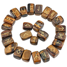 Tiger's eye rune stones arranged in a circle, with brown and golden-banded polished surfaces and gold-coloured characters. The set includes a blank stone.