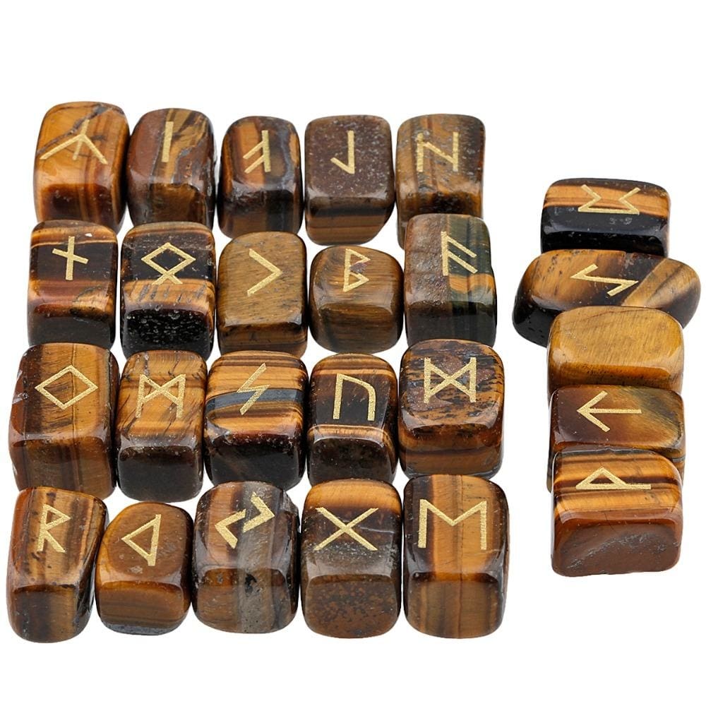 Tiger's eye rune stone set laid out in rows, showing individual gold-coloured characters and one unmarked stone against brown and golden-banded surfaces.