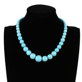 Round turquoise-coloured choker on a necklace bust, showing the larger front beads and smaller beads towards the back.