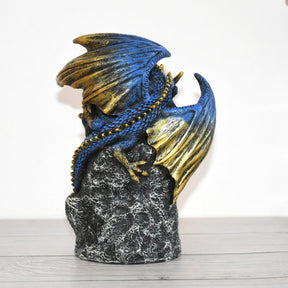 Rear view of the dragon burner, showing overlapping blue scales, gold-tone wings and the rough rock-style back.