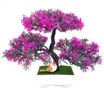 Fuchsia-tipped artificial bonsai foliage forms three rounded clusters over a dark trunk in a white rectangular pot.