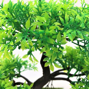 Close-up of small green artificial bonsai leaves, showing their layered shape and two-tone tips.