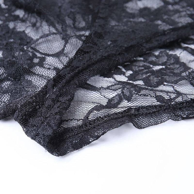 Detail of floral black lace gathered beside the bolero's curved trim, showing the flower shapes and fine open net.