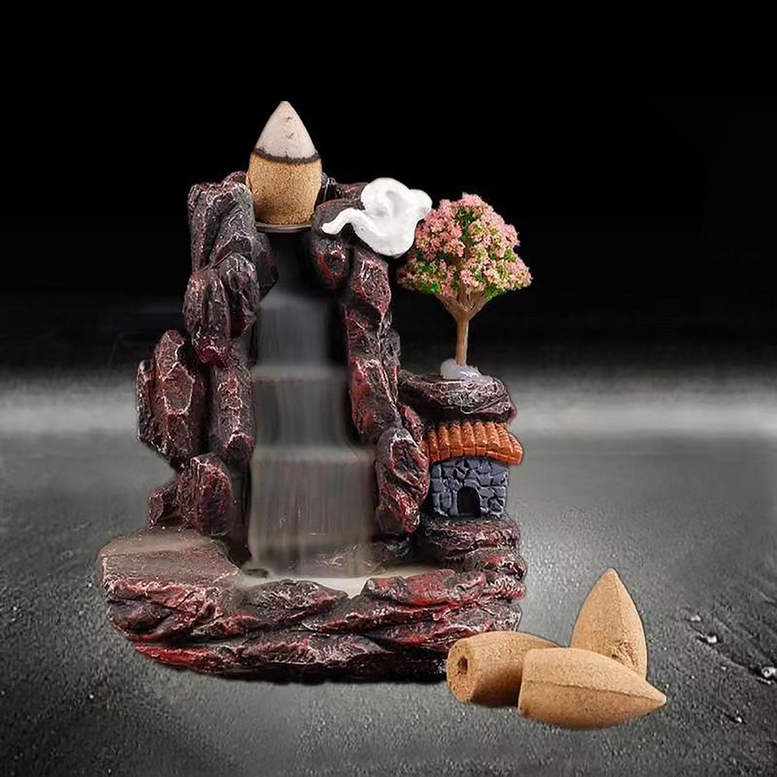 Village backflow incense burner shown with three loose cones beside it, while smoke from the cone on top gathers in the lower basin.