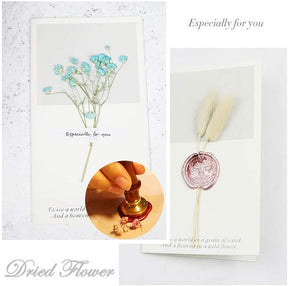 Stationery example with dried flowers and a wax seal, showing a decorative presentation alongside letter-writing accessories.