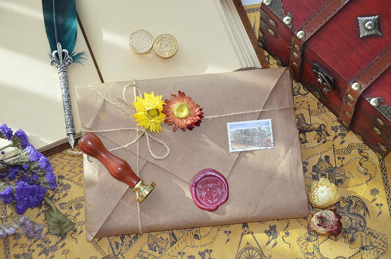 Wax seal stamp displayed with letter-writing materials and an envelope, illustrating a decorative stationery setting.