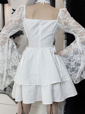 Back view of the white Dark Chapel dress, with fitted bodice seams, long floral lace sleeves and a layered mini skirt with butterfly texture.