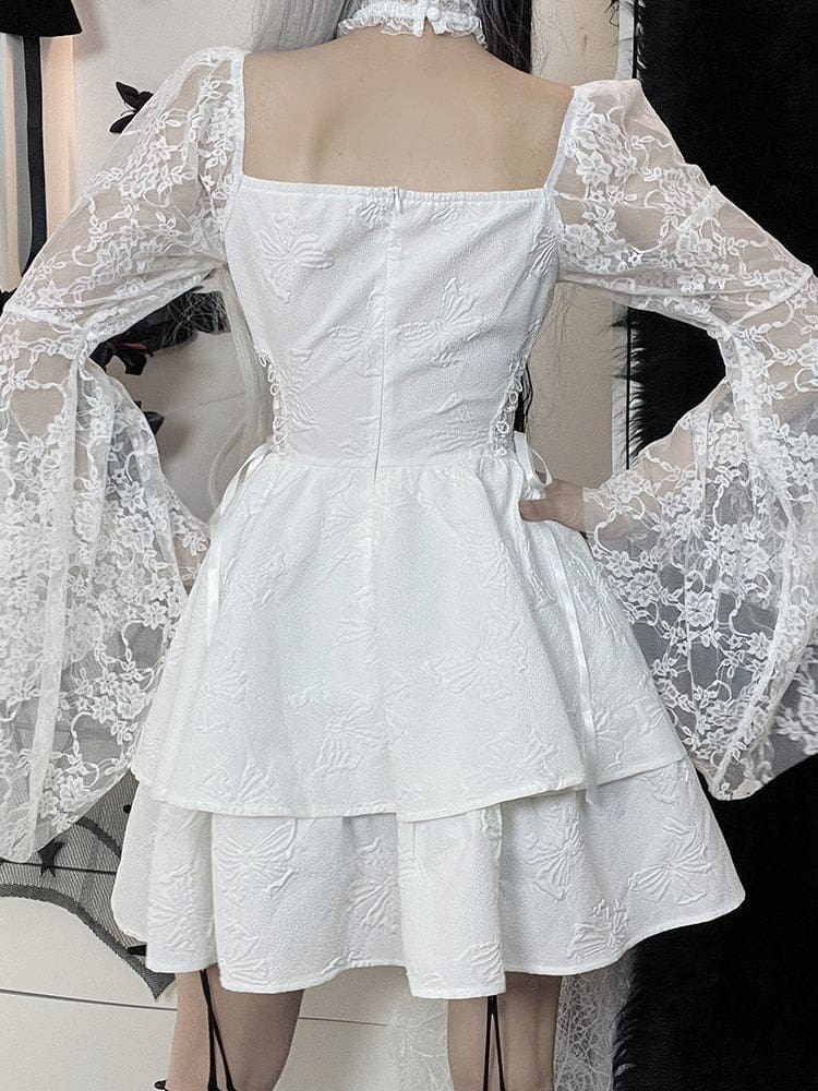 Back view of the white Dark Chapel dress, with fitted bodice seams, long floral lace sleeves and a layered mini skirt with butterfly texture.