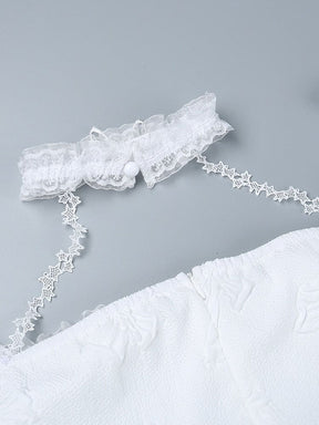 Close-up of the white lace choker opened at its small round button closure. Star-patterned straps connect it to the butterfly-textured dress below.