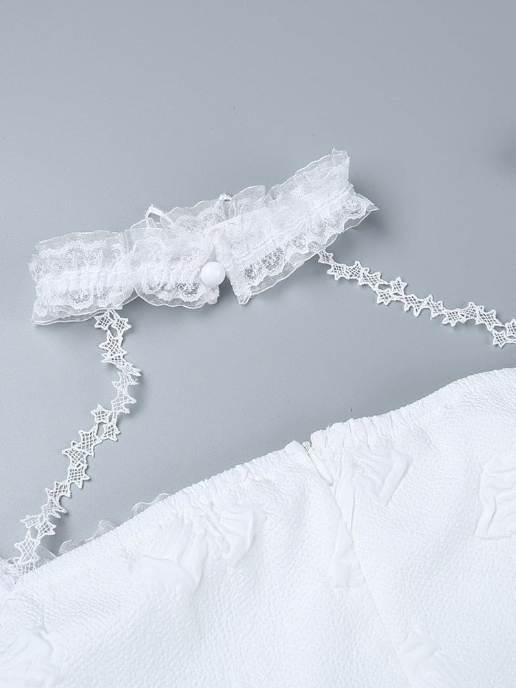 Close-up of the white lace choker opened at its small round button closure. Star-patterned straps connect it to the butterfly-textured dress below.