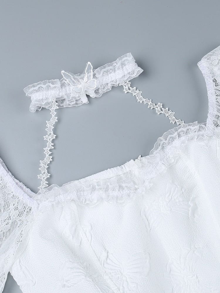 White dress neckline laid flat on a gray background, with its lace choker connected by narrow star-patterned straps above the scalloped bodice edge.