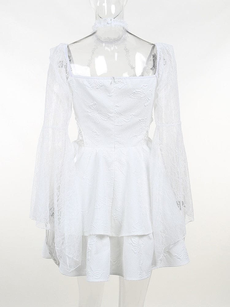 Rear view of the white dress on a clear mannequin, showing the fitted bodice, long lace sleeves and layered hem.
