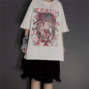 White oversized anime graphic T-shirt styled with frayed black shorts, a long necklace and a patterned wrist covering against a gray wall.