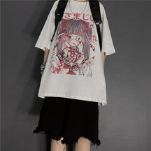 White dark kawaii T-shirt worn with black backpack straps and frayed black shorts. The large anime girl print fills the front beneath a round neckline.