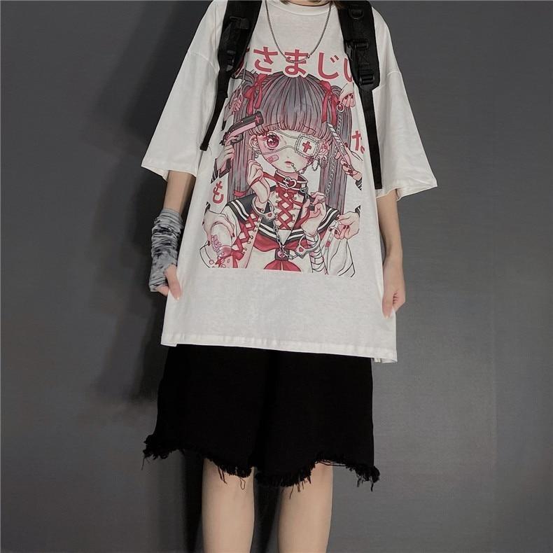 Fuller outfit view of the white anime graphic T-shirt with a black backpack, frayed black shorts and a patterned wrist covering, photographed against a gray wall.