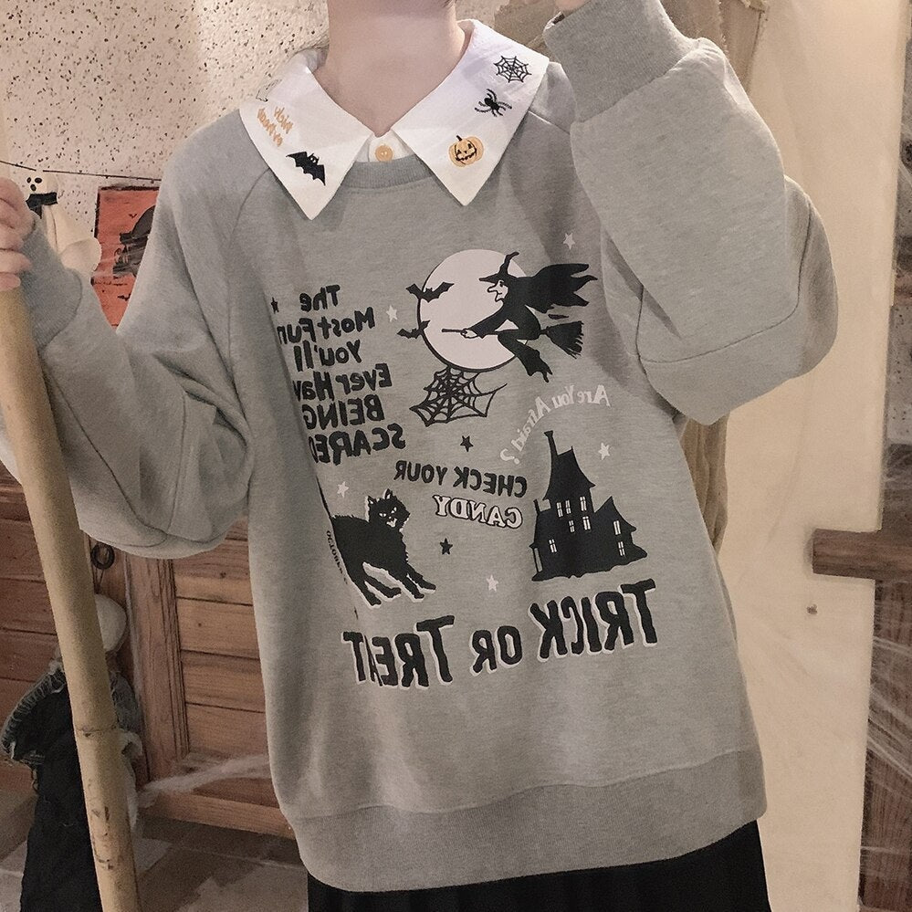 Halloween blouse collar layered over a gray Trick or Treat sweatshirt in a mirror outfit, with embroidered pumpkins, bats and spiderwebs at the neckline.