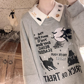 Mirror view of the white Halloween blouse collar over a gray graphic sweatshirt, showing the pointed collar above the witch-and-moon design.