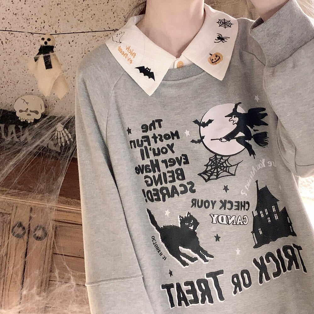 Mirror view of the white Halloween blouse collar over a gray graphic sweatshirt, showing the pointed collar above the witch-and-moon design.
