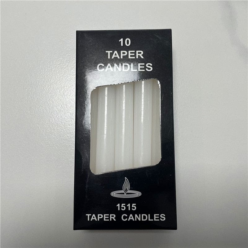 White ritual candles with their packaging, showing slim cylindrical shapes and exposed wicks.