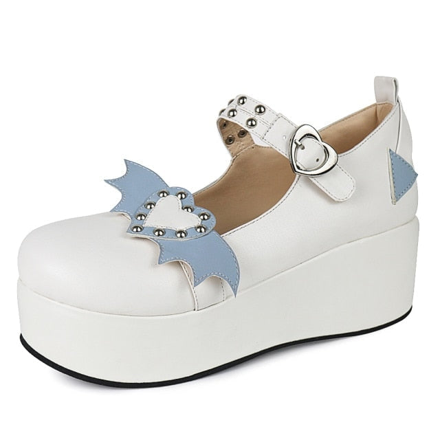 White Winged Heart platform shoe with pale blue accents, a rounded toe and heart-shaped buckle, photographed against white.
