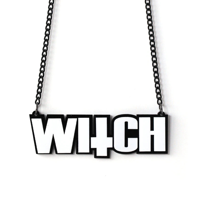 Black and white acrylic WITCH lettering necklace on a black chain, with an inverted-cross shape incorporated into the word.