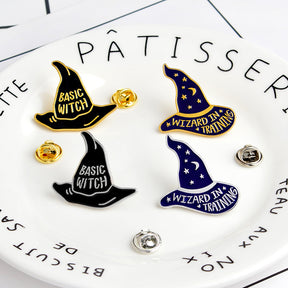 Four witch and wizard hat pins displayed on a plate beside removable butterfly-style pin backs.