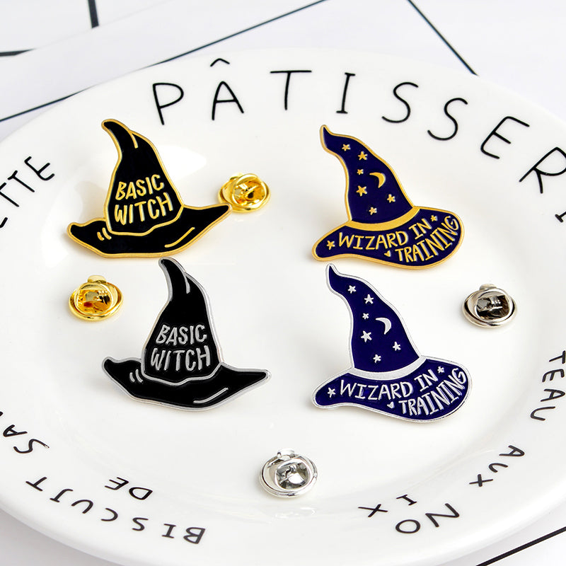 Four witch and wizard hat pins displayed on a plate beside removable butterfly-style pin backs.