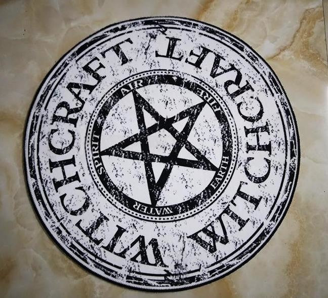 Round witchcraft rug on a tiled floor, with a pale beige print and large dark star at the centre.