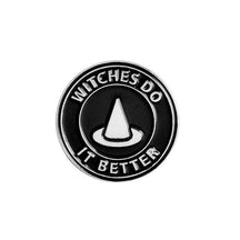 Round black enamel pin with a pointed witch hat and the silver-tone slogan Witches Do It Better.