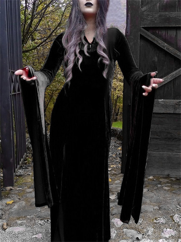 Closer view of the black velvet gown beside a wooden gate, focusing on the waist, slit and hanging sleeve panels.