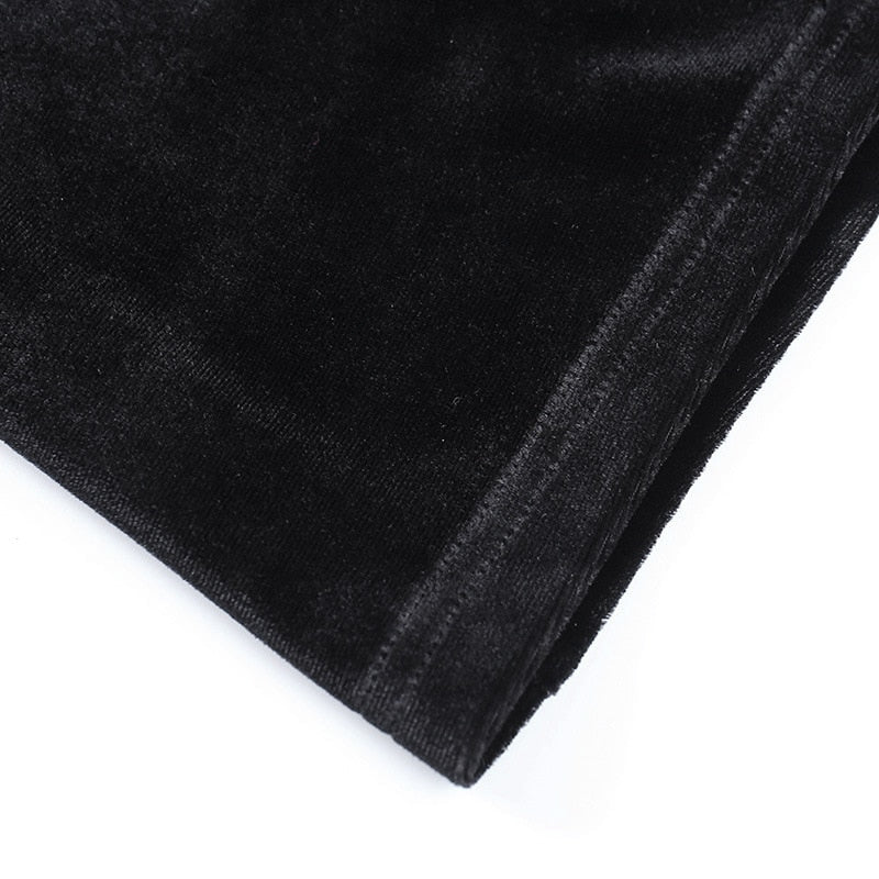 Detail of the gown's stitched hem and softly reflective black velvet surface.