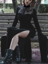 Black velvet gothic gown worn on a wooden bench, showing a floral lace yoke, high slit and deeply draped sleeve.