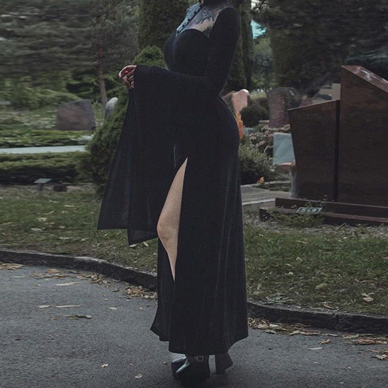 Side view of the black gothic gown outdoors highlighting the fitted waist, high slit and long sleeve drape.