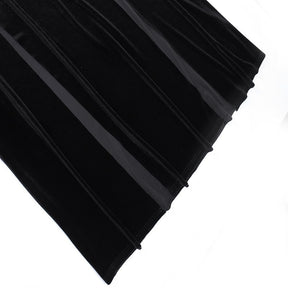 The black velvet skirt spread out to show its flared lower shape and flowing folds.